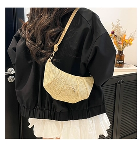Detail of hand-woven crescent bag with butterfly bow and adjustable leather shoulder strap