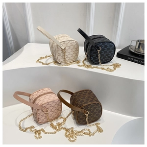 Detailed close-up of mini cylinder crossbody bags with M-pattern and chain straps