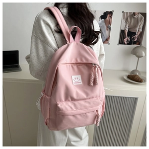 Detailed back view of pink nylon backpack with Barbiebag logo and smile patch detail