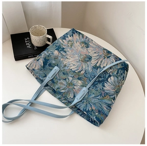 Detail view of jacquard tote bag with blue floral patterns and light blue straps
