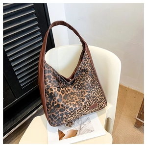 Vue détaillée du sac hobo à imprimé léopard avec bandoulière en cuir sur une chaise