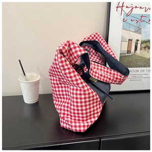 Detailed texture of red and white checkered canvas tote with dark blue denim拼接 details