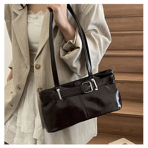 Detail of dark brown glossy oil wax leather shoulder bag with vintage silver buckle strap