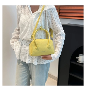 Detail of yellow lychee grain PU leather handbag with Fashion & Bags text on side