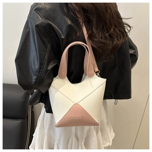 Sac seau bicolore élégant porté à l'épaule par un mannequin pour voir la taille