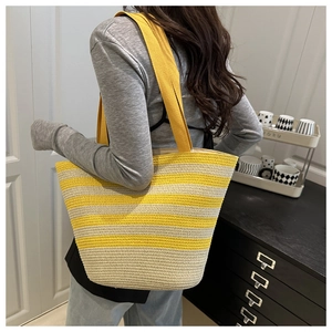 Close-up of yellow and beige striped woven tote bag showing texture and shoulder strap