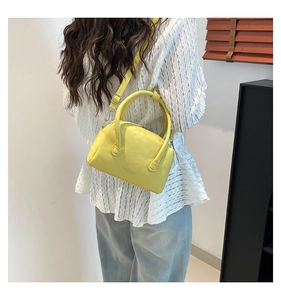 Detail of yellow pebbled PU leather crossbody bag with Fashion & Bags text on casual model