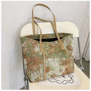 Close-up of floral jacquard tote bag with leather handles on a white chair