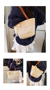 Detail of straw tote bag with lace hollow weaving and brown leather shoulder straps