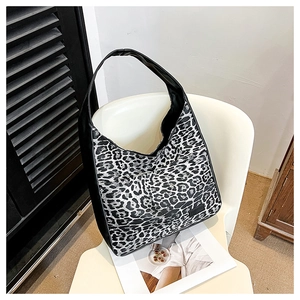 Sac fourre-tout rétro à imprimé léopard noir et blanc avec large bandoulière sur chaise