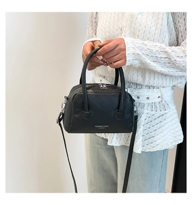 Detail of black lychee grain leather Boston bag with silver hardware and logo