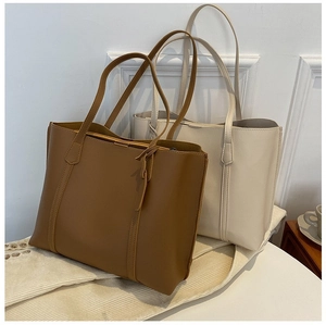 Detail of vintage brown and cream large faux leather tote bags with long shoulder straps