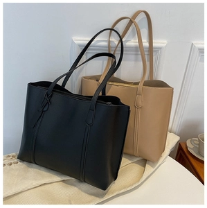 Detail view of large minimalist tote bags in black and beige soft leather for women
