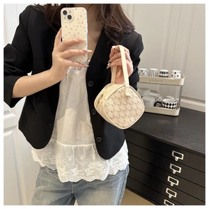 Detail of cream mini square handbag with brown monogram M print and leather handle