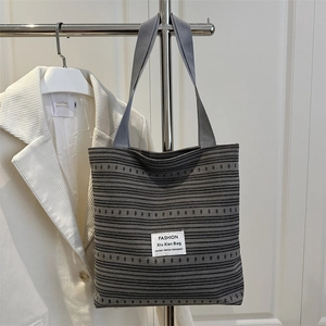 Grand sac cabas en denim à rayures grises et pois accroché sur un mur blanc pur