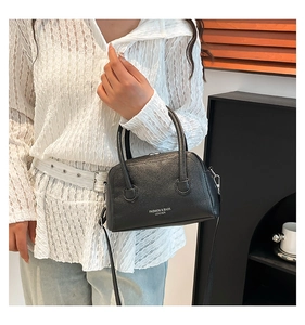 Détail du sac bowling en cuir grainé noir avec lettrage argenté et garnitures métalliques