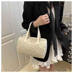 Vista dettagliata della borsa Boston bianca con motivi di lettere M nere e doppi manici