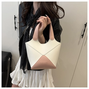 Gros plan d'un sac à main seau rétro bicolore avec détail gravé FASHION