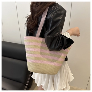 Detail of pink and beige striped woven tote bag with a soft wide fabric shoulder strap