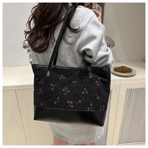 Détail du grand sac cabas en velours côtelé avec motifs cerises et fond en cuir noir