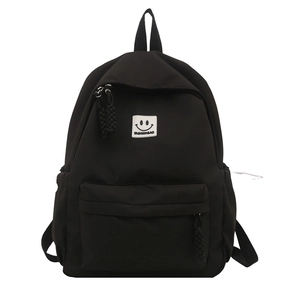 Minimalist black nylon backpack for women featuring fashion smiley logo and front pocket