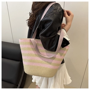 Detailed view of woven tote bag featuring pink and beige stripes with fabric straps