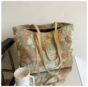 Detail of vintage floral jacquard tote bag featuring premium leather handles and zipper