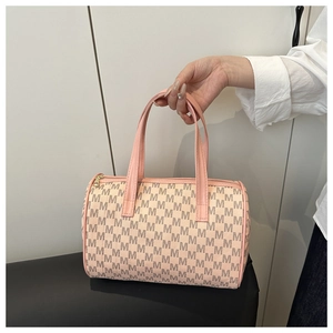 Dettaglio della borsa Boston con stampa di lettere M e manici in pelle rosa vista a mano