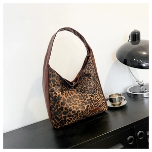 Gros plan du sac fourre-tout léopard avec anses en cuir brun et coutures de qualité