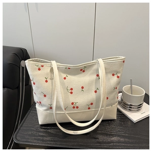 Détail du sac cabas avec motifs cerises et design en patchwork velours et cuir