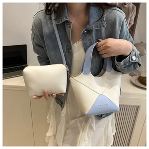 Gros plan d'un sac seau bicolore chic crème et bleu clair avec sa pochette assortie