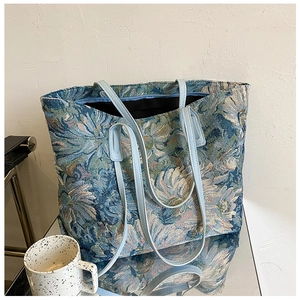Detailed close-up of retro floral jacquard tote bag with blue leather straps and zipper