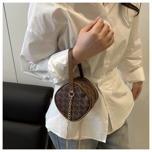Vintage brown barrel bag with letter M monogram print and elegant gold chain strap