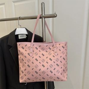 Pink tote bag with cartoon bear patterns and gold rivet details hanging on a metal rack
