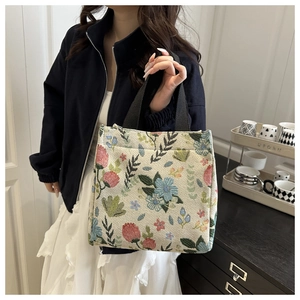 Detailed view of floral knit tote bag with wide black strap and vintage pattern