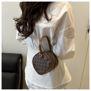 Detailed back view of a retro brown monogram cylinder handbag with gold chain strap