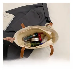 Spacious interior of a straw tote bag showing compartments and inner zipper pocket