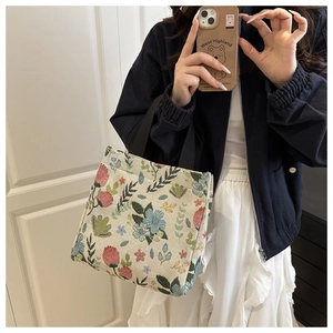 Detailed close-up of retro floral tapestry tote bag with black woven handle straps