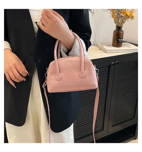 Sac bowling rose en cuir grainé avec poignée incurvée et bandoulière fine en gros plan