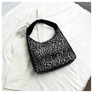 Gros plan sur le sac hobo léopard montrant la toile et la bandoulière en cuir PU noir