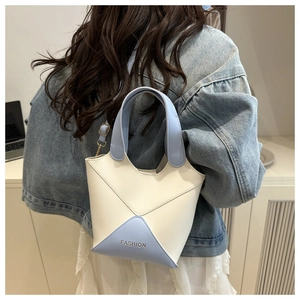Une vue détaillée d'un sac seau en cuir PU bicolore blanc et bleu clair élégant