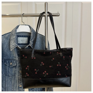 Detail of cherry print corduroy tote bag showing material texture and faux leather base