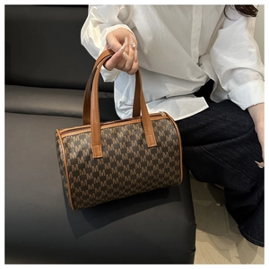 Dettaglio della borsa Boston marrone con monogramma M e cuciture del manico in pelle