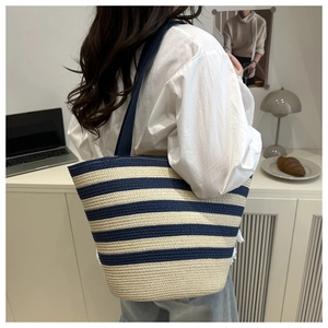 Detail of blue and beige striped woven tote bag showing texture and shoulder strap
