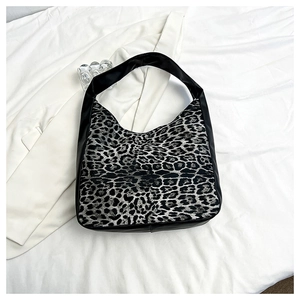Détail du panneau léopard et des coutures en cuir noir sur le sac hobo en forme de croissant
