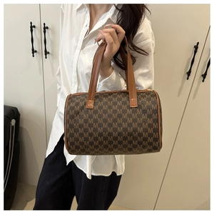 Dettaglio della borsa a bauletto marrone vintage con stampa monogramma e manici in pelle
