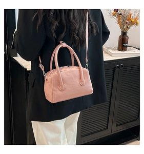 Detailed texture of pink lychee grain leather crossbody bag with slim shoulder strap