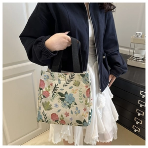 Detail of floral tapestry tote bag with woven texture and durable black handles