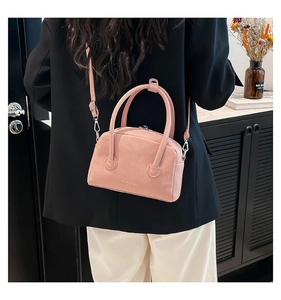 Pink lychee grain leather handbag with detachable strap shown on a black blazer outfit