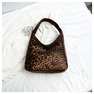 Gros plan du sac hobo à motif léopard avec bordure en cuir marron et texture poulain